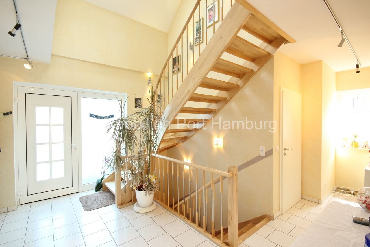 Lichtdurchfluteter Eingangsbereich mit eleganter Holztreppe - Ihr Willkommens-Highlight!