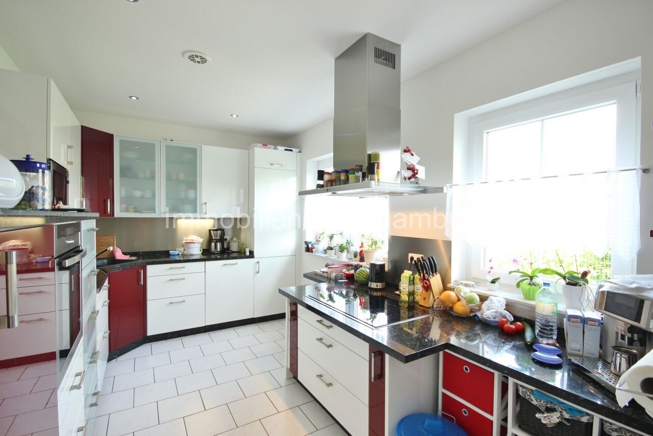 Brightly lit designer kitchen with island and high-quality granite countertop Brightly lit designer kitchen with island and high-quality granite countertop